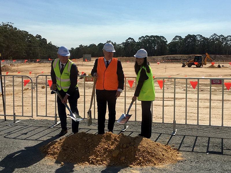 Toll Group's Michael Byrne, centre, breaks ground at the Arundel site, alongside Logos' John Marsh and Kelly Xu of Partners Group)