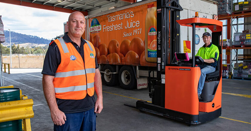 Juicy Isle warehouse and logistics manager, Glen Mackenzie (left) and forklift operator, Tim Williams, on one of the new Toyota BT RRE160M electric reach forklifts. Mr Mackenzie said the new machine replaced one sold into the business 20 years ago, proving how reliable and durable the BT reach trucks are.